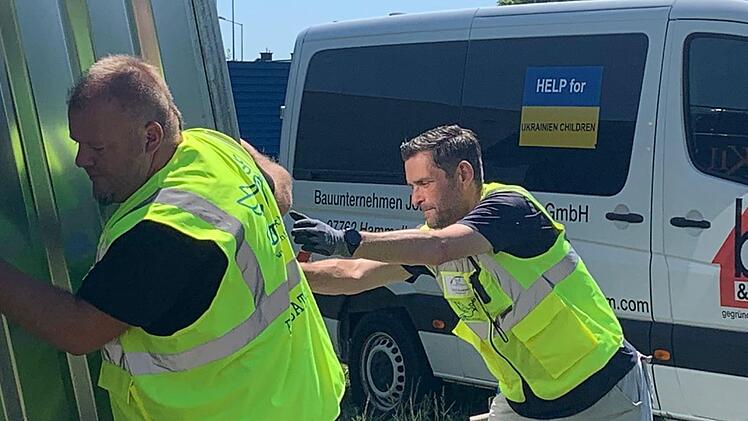 Anpacken f&uuml;r die Menschen in der Ukraine: Christian Wirth (links) und Dirk Stumpe von der Initiative "Bad Br&uuml;ckenau hilft" beim Aufstellen eines Materialcontainers. Foto: Oliver Belz