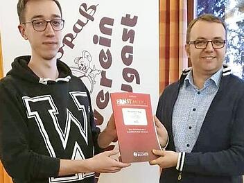 Tobias Bunzel (rechts) übergab dem Dirigenten des Musikvereins Marktleugast, Julian Will, drei Notenausgaben "Böhmische Blasmusik".  Foto: Werner Reißaus