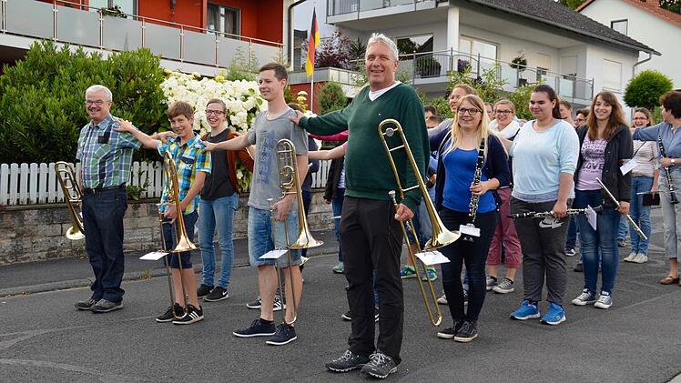 Wie kommt ein Orchester um die Kurve? Das üben die Bläser seit einiger Zeit mit ihrer Dirigentin Manuela Möller. Um den Abstand zu erspüren, legen hier die Musiker den rechten Arm auf die Schulter ihres Nachbarn.  Foto: Kathrin Kupka-Hahn