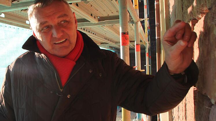 Jürgen Kober erklärt, wie die Fugen in der Buntsandstein-Fassade der Lindesmühle erneuert werden.  Fotos: Benedikt Borst