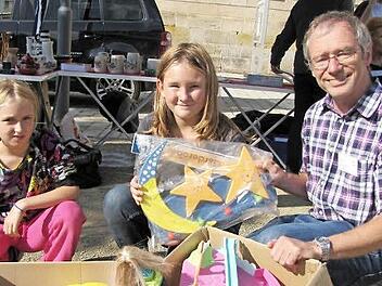 Chantal und Celina packen ihr Spielzeug vom Flohmarktstand ein und geben es an Peter Schubert, der es wiederum an syrische Flüchtlingskinder weitergeben soll.  Fotos: Hermann Fechter