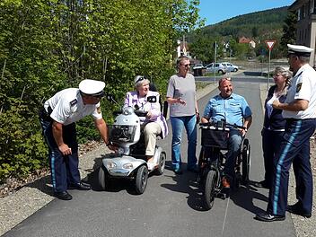 Erster Polizeihauptkommissar Herbert Markert (rechts) und sein Kollege Klaus Wiesler (links) nahmen bereits vor der Infoveranstaltung einige Mobilitätshilfen der Teilnehmer in Augenschein. Mit den Beamten freute sich auch der Organisator des Treffens, Andreas Knüttel (3.von rechts) darüber, dass es an den Fahrzeugen nichts zu beanstanden gab. Foto: Rolf Pralle
