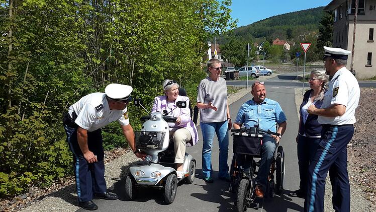 Erster Polizeihauptkommissar Herbert Markert (rechts) und sein Kollege Klaus Wiesler (links) nahmen bereits vor der Infoveranstaltung einige Mobilitätshilfen der Teilnehmer in Augenschein. Mit den Beamten freute sich auch der Organisator des Treffens, Andreas Knüttel (3.von rechts) darüber, dass es an den Fahrzeugen nichts zu beanstanden gab. Foto: Rolf Pralle