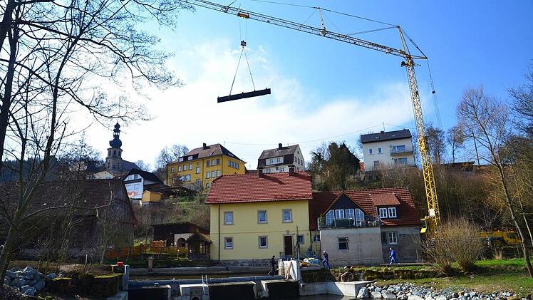 Mit einem schweren Autokran wurden die Einzelteile für die neue Wehrklappe über die frühere Trebgaster Mühle an den Weißen Main gehievt. Foto: Dieter Hübner
