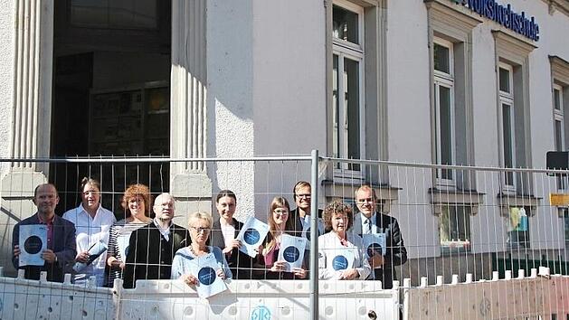 Eric Escher, Gabriele B&auml;tz, Sylke Hahn, Helge Kienel, Anja Reisenweber, Nadine D&uuml;thorn, Franziska Knauer, Oliver He&szlig;, Helga Kolbenschlag und Rainer Maier vor der Volkshochschule, deren Zugang durch die Baustelle bis November erschwert wird  Foto: Svenja Sollmann