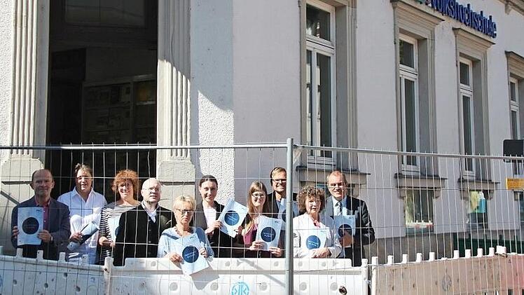 Eric Escher, Gabriele B&auml;tz, Sylke Hahn, Helge Kienel, Anja Reisenweber, Nadine D&uuml;thorn, Franziska Knauer, Oliver He&szlig;, Helga Kolbenschlag und Rainer Maier vor der Volkshochschule, deren Zugang durch die Baustelle bis November erschwert wird  Foto: Svenja Sollmann
