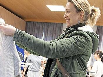 Silvia Erhard hat auf der Kleidertauschparty einen grauen Strickpulli und eine Bluse gefunden. Foto: Katharina Müller-Sanke