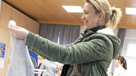 Silvia Erhard hat auf der Kleidertauschparty einen grauen Strickpulli und eine Bluse gefunden. Foto: Katharina Müller-Sanke