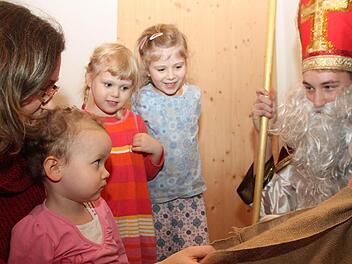 Vor dem freundlichen Nikolaus muss  sich niemand fürchten. Das stellen Judith, Ida und Magdalena (von links) schnell fest. Mit im Bild Judiths Mutter Steffi Posel. Ins Nikolausgewand ist Max Heiß geschlüpft. Foto: Alexander Hartmann