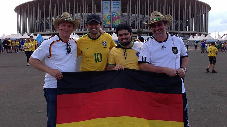 Winfried Gräf (links) und Leo Will müssen vor dem Nationalstadion in Brasilia Hunderte von Bildern mit sich und ihre Deutschland-Fahne machen lassen,was ihnen - wie man sieht - nicht schwergefallen ist.