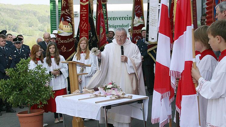 Pfarrer Josef Schirner beim Segnen der drei Kreuze. Foto: Erlwein