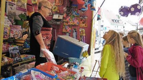 Silvia (l.) ist hinter der Kasse ihrer Losbude voll in ihrem Element