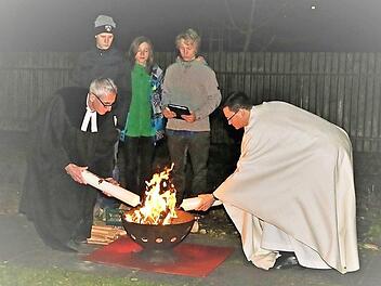 Pfarrer Walter Neunhoeffer (links) und Pfarrer Matthias Bambynek entzünden am Osterfeuer die Osterkerze der jeweils anderen Gemeinde. Das Foto entstand im Jahr 2016. Foto: Zimmermann