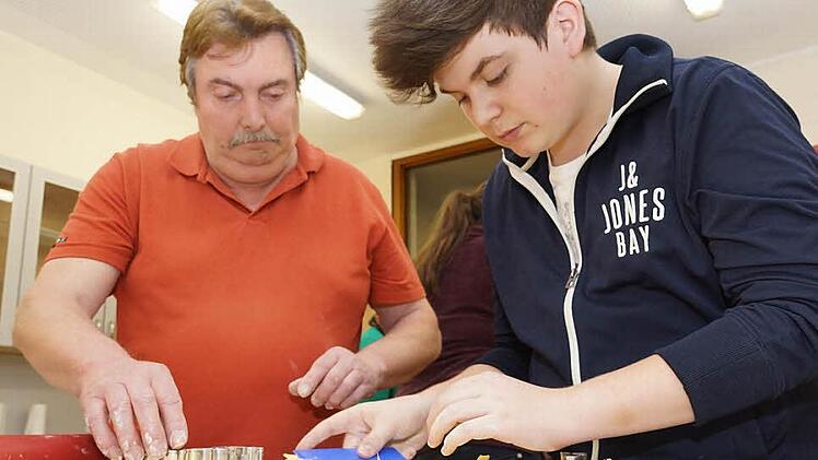 Teamarbeit: Winfried Bauer (links) und Lukas Mützel stechen Formen aus Teig aus. Foto: Arkadius Guzy