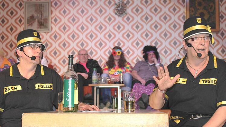 Alkohol im Dienst? Vor den Augen des Chefs, der hinten in der Mitte das Geschehen verfolgt? Für die neuen Stadtpolitessen Resi (Christiane Garreis, rechts) und Babet (Susanne Wolfschmitt) kein Problem. Das sie nur halbamtlich tätig sind, können sie auch einen halben Schoppen trinken! Foto: Ralf Naumann