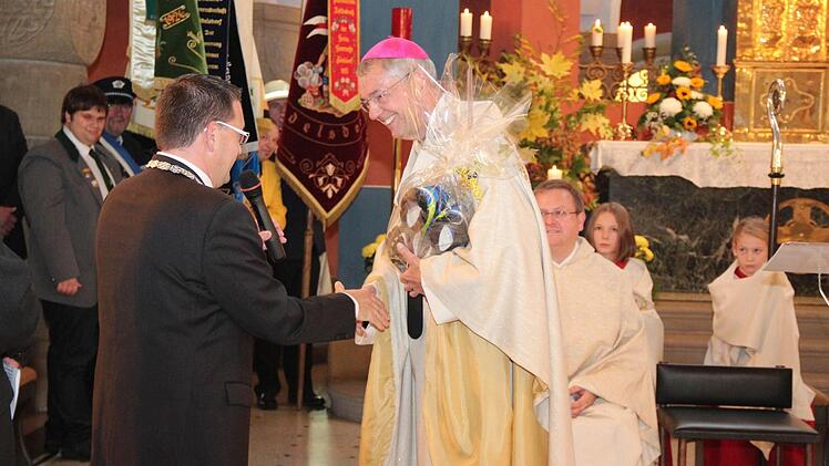 Der Erzbischof freut sich über die Laufschuhe vom Bürgermeister