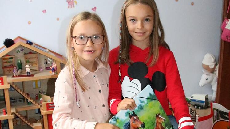 Gut, eine ältere Schwester zu haben: Die neunjährige Lena (rechts) hilft ihrer sechsjährigen Schwester Viktoria nicht nur beim Packen der Büchertasche, sondern gibt auch Tipps zum Schul-Alltag. Foto: Ralf Ruppert