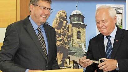 Schlüsselübergabe durch den Architekten Udo Freitag (links) an Bürgermeister Helmut Fischer. Ein Baum als Geschenk wird folgen.
