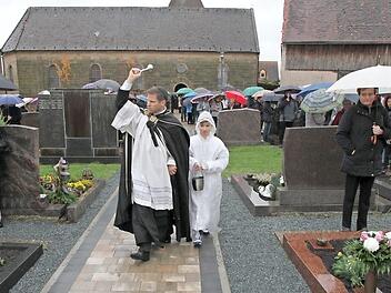 Der Pfarrer Matthias Steffel weiht den neu gestalteten Friedhof in Schnaid. Foto: Mathias Erlwein