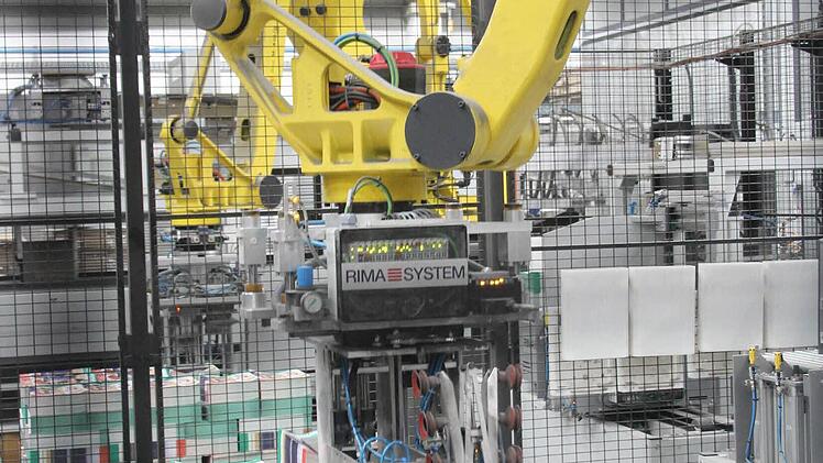 Ein Greifroboter stapelt die fertigen Prospekte. Foto: Daniel Ruppert