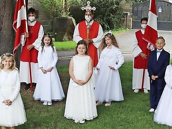 Die Erstkommunionkindern mit Diakon Konrad Funk (hinten links) und Pfarrer Gerhard M&ouml;ckel (hinten rechts) nach dem Gang zu ihrer ersten Heiligen Kommunion