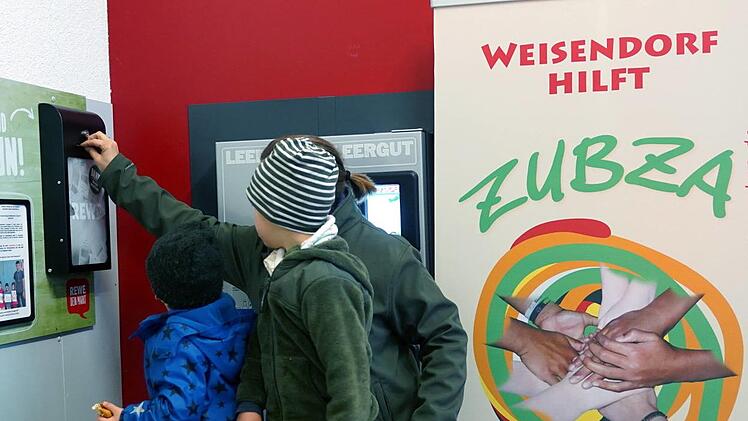 Elisabeth Schneider und ihre Söhne Finn und Jonas spenden ihren Pfandbon für die Kinder in Zubza.    Foto: Richard Sänger
