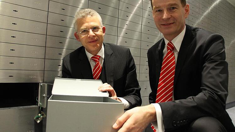 Die Sparkassenvorstände Roland Friedrich (links) und Michael Rendl öffnen im Tresorraum ein Schließfach. Sie wollen Sparer nicht mit Strafzinsen belasten. Foto: Benedikt Borst