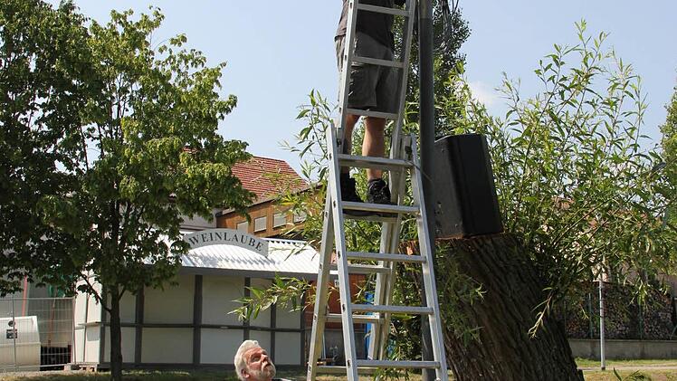 Der richtige Ton macht`s: Thomas Zösch hält die Leiter, während Alexander Stütz in luftiger Höhe Lautsprecher montiert.  Foto: Dominik Schreiner
