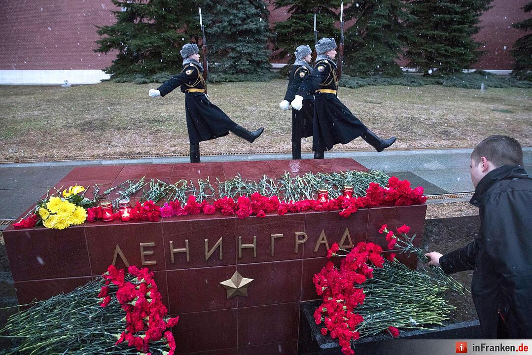 Beim Wachwechsel legt ein Mann Blumen nieder für die Opfer der Explosion in einer U-Bahn in St.Petersburg