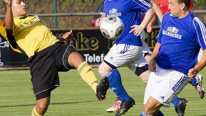 Im Mittelfeld versucht der Frohnlacher Jannik Schmidt (gelb) mit einem langen Bein noch vor Jochen Hollfelder an die Kugel zu kommen. In der Mitte Daniel Weiner. Foto: Heinrich Weiß