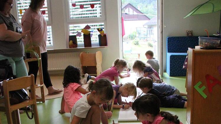 Kinder aus dem Regenbogenland bemalen die Papierrollen, aus denen das größte selbstklebende Bild der Welt entstehen soll. Foto: Ulrike Müller