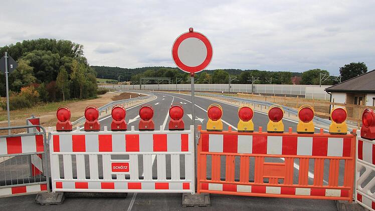 Noch stehen Absperrungen wie hier an der Mainbrücke auf der neuen Straße, die das Industriegebiet anbindet und den alten Bahnübergang ersetzt. Fotos: Tobias Kindermann