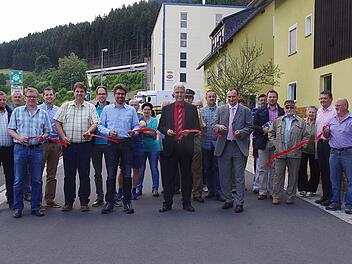 Im Beisein beteiligter Bau- und Planungsvertreter, Mitglieder des Stadtrates als auch Anwohner gab Bürgermeister Timo Ehrhardt (Mitte) am Donnerstag die ausgebaute Alte Poststraße in Ludwigsstadt offiziell für den Verkehr frei.  Foto: Heike Schülein