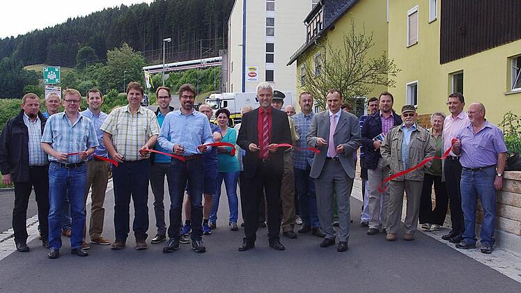 Im Beisein beteiligter Bau- und Planungsvertreter, Mitglieder des Stadtrates als auch Anwohner gab Bürgermeister Timo Ehrhardt (Mitte) am Donnerstag die ausgebaute Alte Poststraße in Ludwigsstadt offiziell für den Verkehr frei.  Foto: Heike Schülein