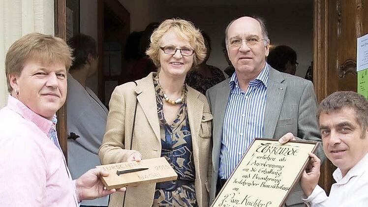 Glückwunsch 1: Altstadtvereins-Kassier Wolfgang Joa (rechts) und Vorsitzender Peter Braun (links) übergeben den Mürschter Nagel an Gertrud und Martin Kuchler. Foto: Björn Hein