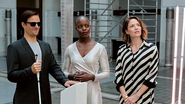Solveig (Florence Kasumba, Mitte), die Frau eines reichen Bankiers, empfängt Haller (Philipp Hochmair) und seine Schwester Sophie (Patricia Aulitzky) zur Vernissage.