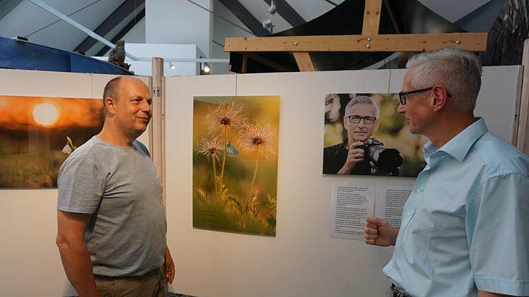 Der Oberelsbacher Naturfotograf  Wolfgang Omert (rechts) zeigt im Haus der Langen Rhön faszinierende  Naturaufnahmen in malerischer und verträumter Schönheit. Mit Michael  Dohrmann spricht er über die Besonderheit der Aufnahmen. Foto: Marion  Eckert