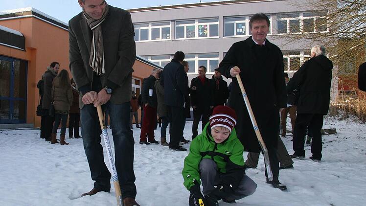 Mit großem Hallo  versuchten der Leiter der Sekundarstufe, Mathias Schmitt und Franz Urban (9) sowie der Bürgermeister Hans-Peter Laschka (rechts) den ersten Spatenstich für den Neubau an der Montessori-Schule zu machen. Doch bei den aktuellen Minustemperaturen ist an Buddeln nicht zu denken. Trotzdem sind die Planungen jetzt genehmigt. Baubeginn  ist baldmöglichst.