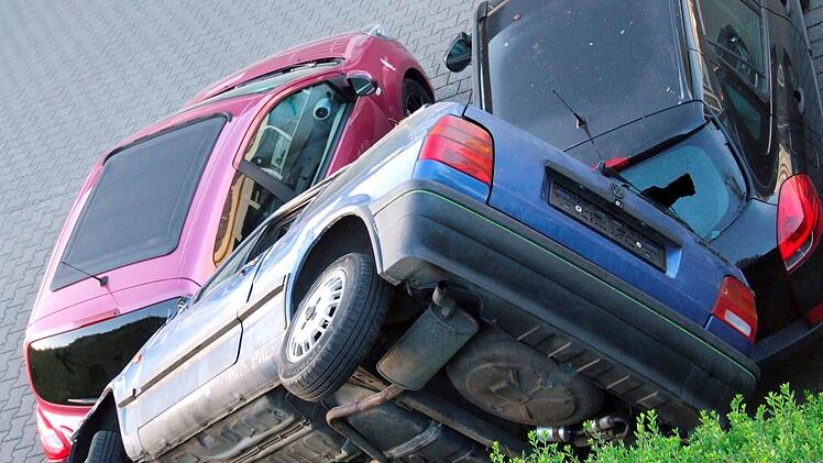 B&uuml;dingen: In ungew&ouml;hnlicher Position liegt ein Auto auf zwei anderen Fahrzeugen. Laut der ermittelnden Polizei war ein Unfall Ursache der &laquo;ungew&ouml;hnlichen Parkposition&raquo;. Foto: Polizeipr&auml;sidium Mittelhessen/dpa