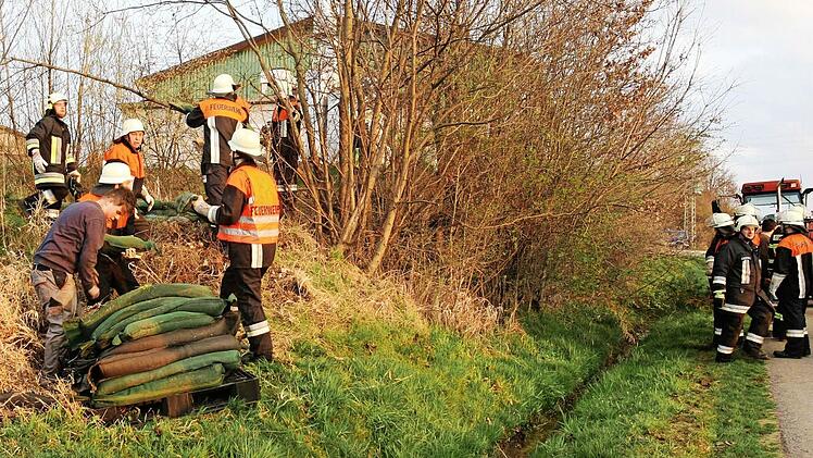 Feuerwehrleute versuchen am Dienstag mit mehreren Pumpen, die Gülle in ein Klärbecken zu leiten. Fotos: Stefan Johannes