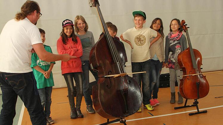 Natürlich durften die Schüler bei der Instrumentenkunde selbst Hand anlegen, hier am Kontrabass und dem Cello. Foto: Günther Geiling