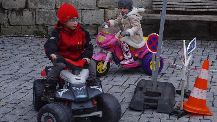 Federico und Mia flitzen mit den Elektro-Fahrzeugen über den Marienplatz.