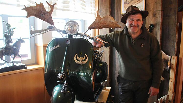 Josef Sanfilippo präsentiert in Jägerkluft die grüne Vespa "cacciatore". In den Damhirschschaufeln befinden sich übrigens die Rückspiegel - und falls ein angeschossener Keiler schnaubend die Verfolgung aufnehmen sollte, kann der türmende Waidmann seine nach hinten montierte Flinte nach der Manier von James Bond im Davonpreschen abfeuern. Fotos: Matthias Einwag