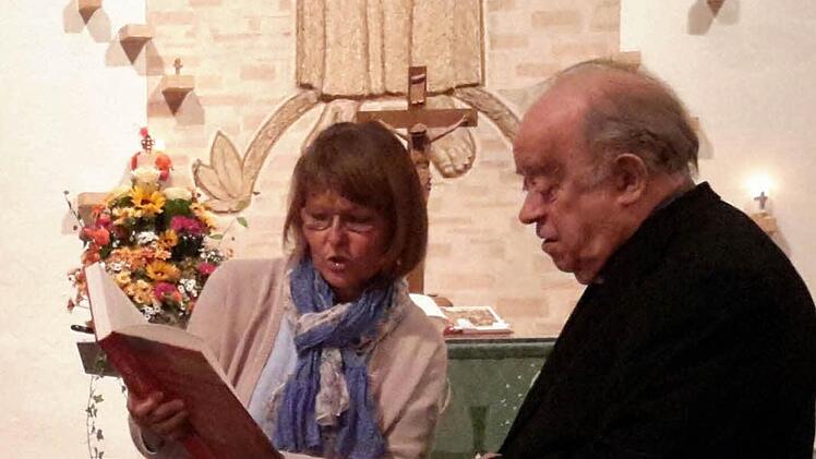 Ökumene live: Die evangelische Pfarrersgattin Martina Kirchner überreichte dem katholischen Bischof em. Paul Werner Scheele ein Buchpräsent. Zuvor hatte der Geistliche in der Friedenskirche einen vielbeachteten Vortrag gehalten. Foto: Rolf Pralle