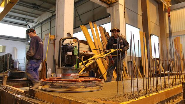 Ein Arbeiter beim Gl&auml;tten des noch fl&uuml;ssigen BetonsFoto: Adriane Lochner