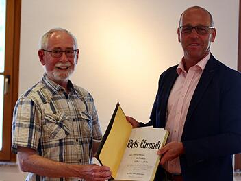 Gerwin Kellermann (links) übergibt eine wichtige Sammlung von historischen Aufzeichnungen an die Marktgemeinde Wildflecken. Bürgermeister Gerd Kleinhenz (PWW) dankte für die unermüdliche Arbeit rund um die Dokumentation der Ortsgeschichte.  Foto: Sebastian Schmitt