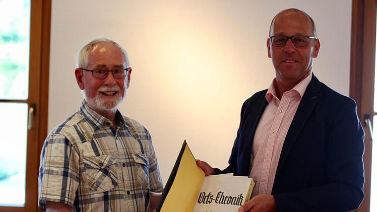 Gerwin Kellermann (links) übergibt eine wichtige Sammlung von historischen Aufzeichnungen an die Marktgemeinde Wildflecken. Bürgermeister Gerd Kleinhenz (PWW) dankte für die unermüdliche Arbeit rund um die Dokumentation der Ortsgeschichte.  Foto: Sebastian Schmitt