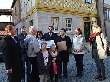Peter Hofmann zeigt den Gästen anhand einer aufgestellten Fototafel das "Vorher" und "Nachher" der umfangreichen Restaurierung.Das alte Ackerbürgerhaus präsentiert sich im kräftigen roten Ocker.