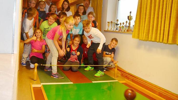 Das Kinder-Kegeln im Rahmen des Ferienprogramms ist ein tolles Vergnügen, bei dem Spaß und Spannung vorherrschen. Vorne links ist Neuling Lara Stark, die erstmals teilnimmt und gegen den "alten Kegel- Hasen" Jonas Neubauer antritt, der schon im dritten Jahr am Kegeln teilnimmt. Im Hintergrund beobachten Zweiter Bürgermeister Arno Hoffmann (links) und Bürgermeister Hans Pietz das Geschehen. Foto: K.-H. Hofmann