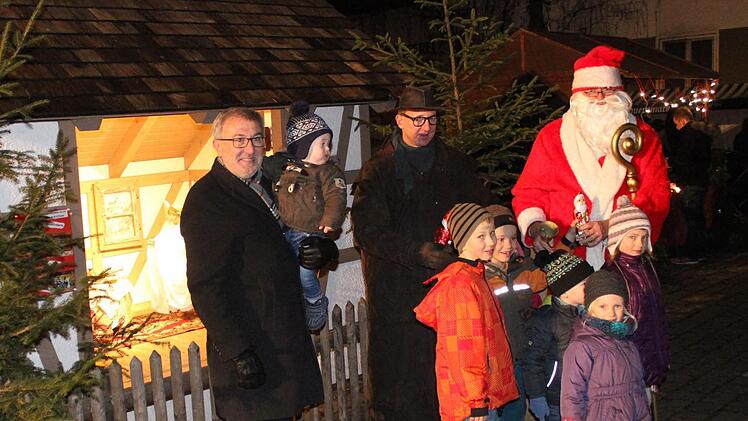 Auch für Bürgermeister Helmut Krämer und sein Enkelkind Lennard hatte der Nikolaus auf dem Weihnachtsmarkt etwas dabei. Foto: fra-press